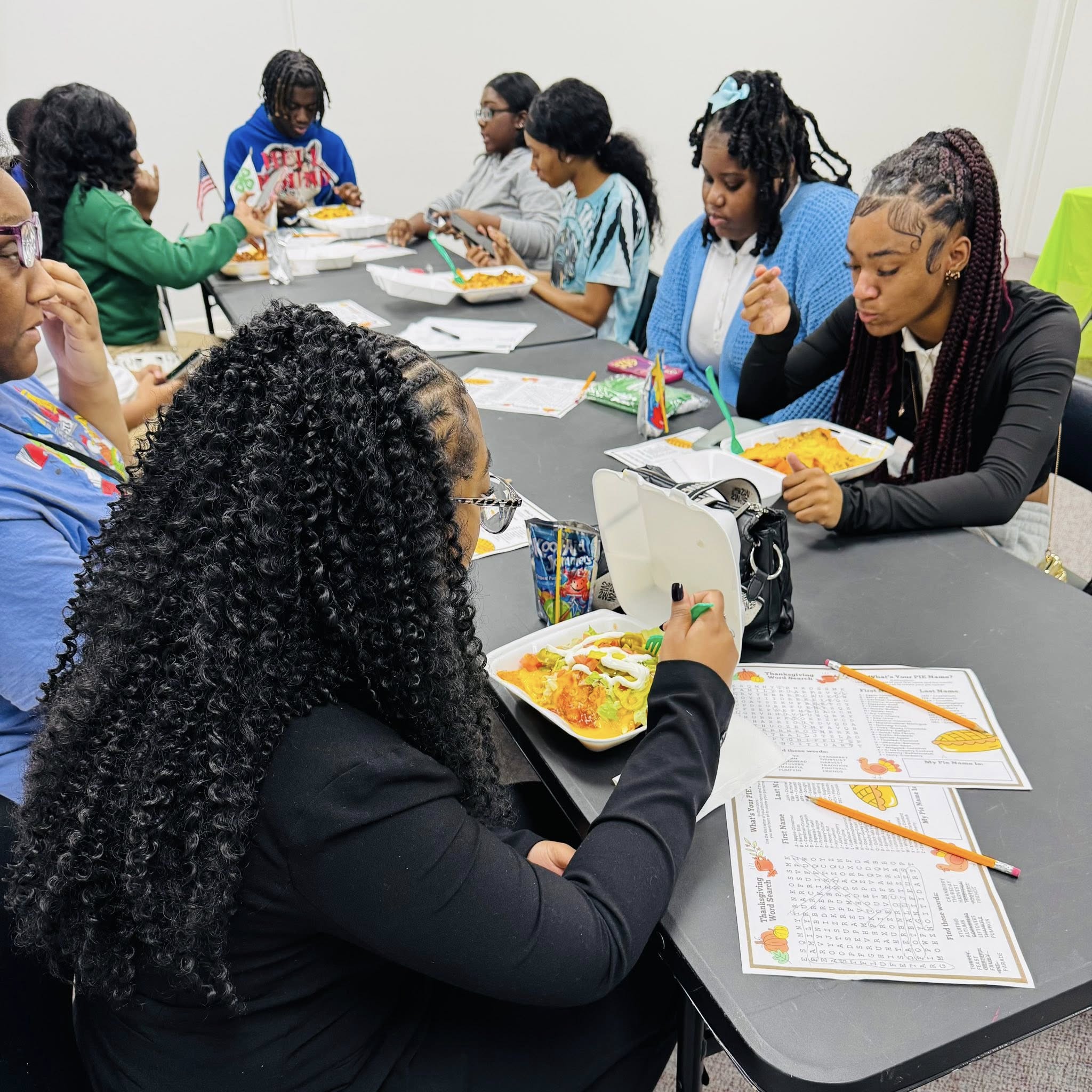A group of teens eating at a table.